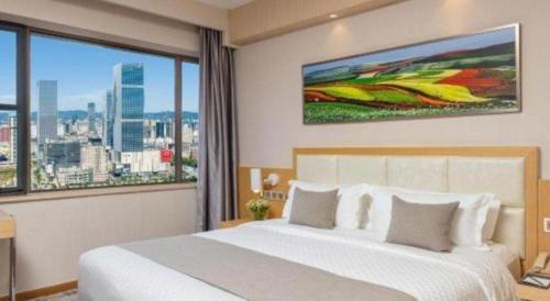 a bedroom with a large bed and a large window at Kunming Jinjiang Hotel in Kunming
