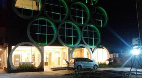 a car parked in front of a building at night at Fovere Hotel Palangkaraya in Palangkaraya