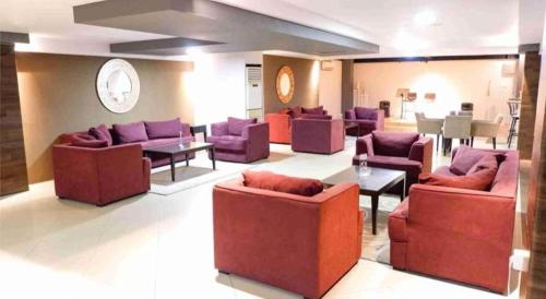 a living room with couches and tables in a room at Grage Hotel Cirebon in Cirebon