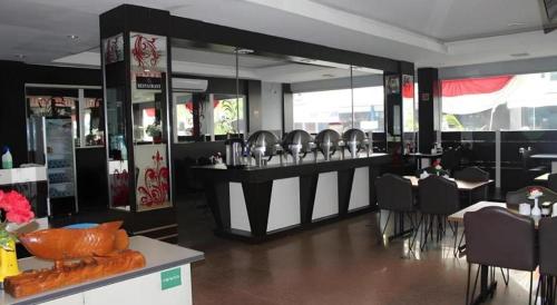 a restaurant with tables and chairs and a bar with mirrors at Balai View Hotel in Tanjung Balai Karimun