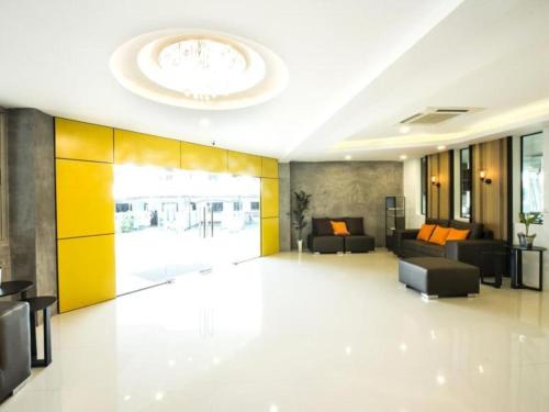 a large living room with a couch and a chandelier at The Circle Hotel in Buriram