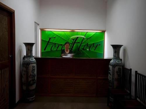 a woman in a mirror in a room with two vases at Forest Floor Lodge in Cat Tien