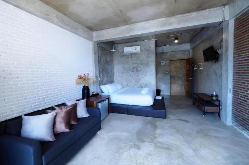 a bedroom with a bed and a couch in a room at The River Life Resort in Ban Kaeng Raboet