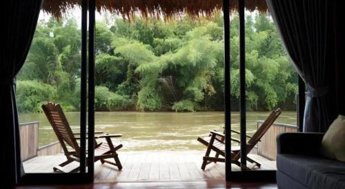 a room with two chairs and a view of a river at The River Life Resort in Ban Kaeng Raboet