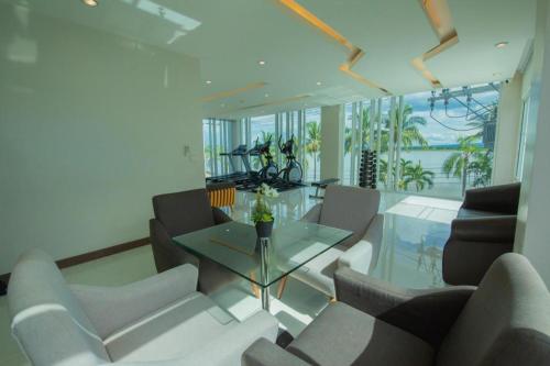 a living room with chairs and a glass table at Phuglong Hotel in Phayao