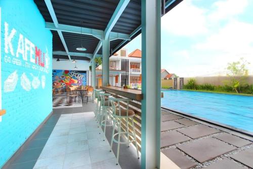 an outdoor patio with a bar and a swimming pool at Umah Bali Suites in Denpasar