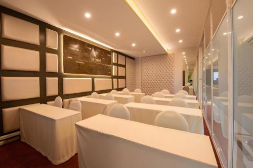 a dining room with white tables and white chairs at Phuglong Hotel in Phayao