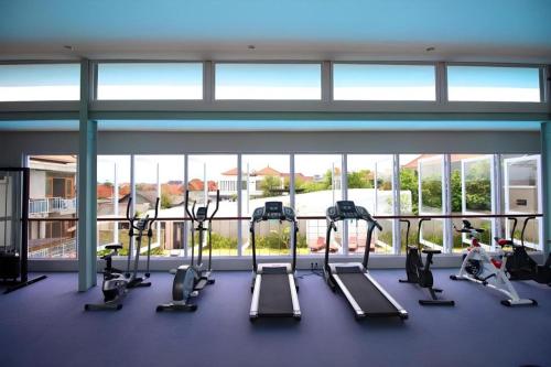 a gym with treadmills and ellipticals in a building at Umah Bali Suites in Denpasar