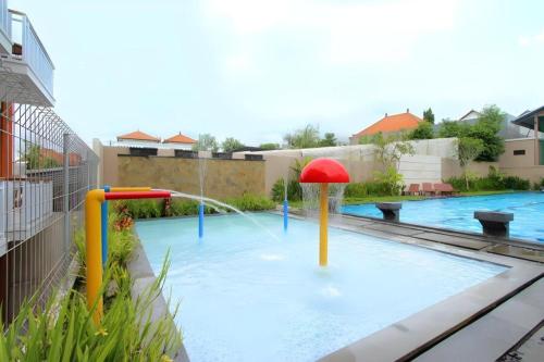 a swimming pool with a water park with a fountain at Umah Bali Suites in Denpasar
