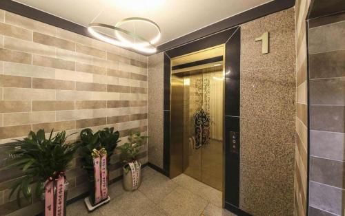 a hallway with a door and plants in a building at Hotel Primo Daejeon in Daejeon