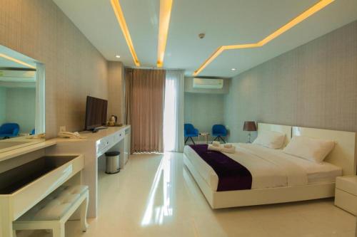 a bedroom with a bed and a desk and a sink at Phuglong Hotel in Phayao