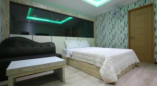 a bedroom with a bed and a bench in it at Hotel Primo Daejeon in Daejeon
