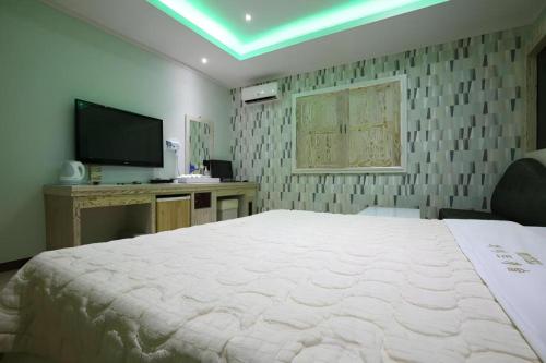 a bedroom with a large bed and a tv at Hotel Primo Daejeon in Daejeon