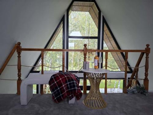 un lit dans une chambre avec une grande fenêtre dans l'établissement Aframe Lac Malei, à Petrila