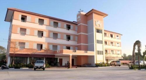 a large building with a clock tower in a parking lot at Thatphanom View Hotel Nakhon in Nakhon Phanom