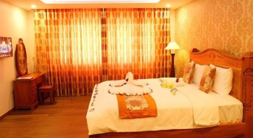 a bedroom with a large white bed in a room at New Palace Bac Lieu Hotel in Bạc Liêu