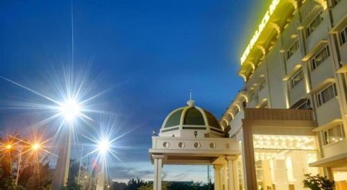 a building with a white dome next to a building at New Palace Bac Lieu Hotel in Bạc Liêu