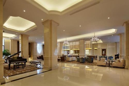 a lobby with a grand piano and a living room at Yin Run Jin Jiang Castle Hotel in Huzhou