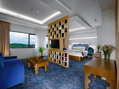a hotel room with a bed and a living room at CK Tanjungpinang Hotel and Convention Centre in Tanjung Pinang 