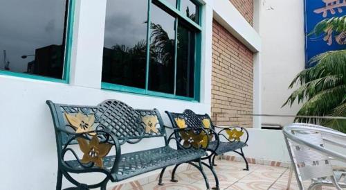 a green bench sitting outside of a house at Lai Ming Hotel Cosmoland in Singapore