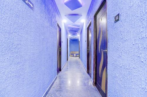 an empty hallway with blue walls and a hallway with doors at Super Collection O Nagapattinam Bus Terminal Formerly Yazhisai Residency in Nāgappattinam