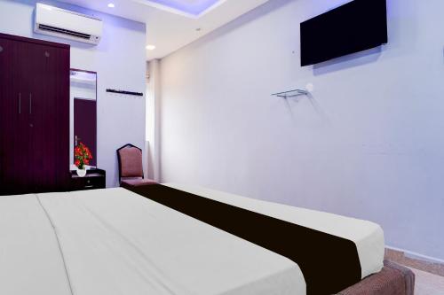 a bedroom with a bed and a tv on the wall at Super Collection O Nagapattinam Bus Terminal Formerly Yazhisai Residency in Nāgappattinam