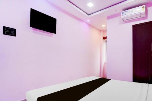 a room with a bed and a tv on a wall at Super Collection O Nagapattinam Bus Terminal Formerly Yazhisai Residency in Nāgappattinam