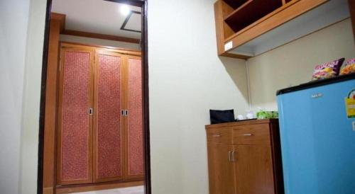 a kitchen with a blue refrigerator and a wooden cabinet at AmornSukhothai Hotel in Sukhothai