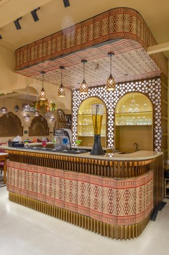 a bar at a restaurant with a patterned counter at Honeyveils Palace Hotel - Behind Indian Expo Mart in Greater Noida