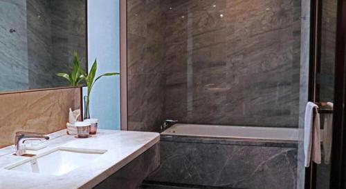a bathroom with a sink and a bath tub at Rosedale Hotel Taicang in Taicang