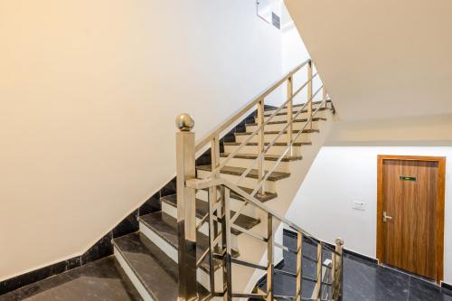 a staircase in a house with a wooden door at Honeyveils Palace Hotel - Behind Indian Expo Mart in Greater Noida