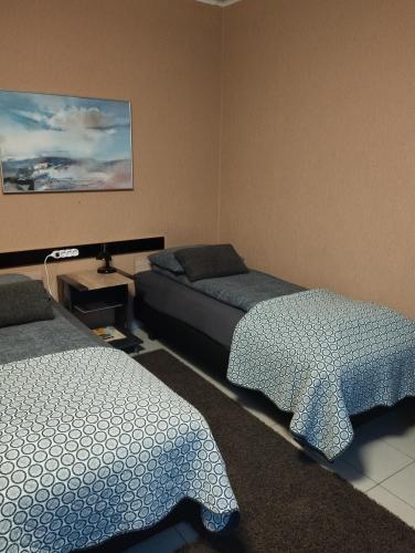 a bedroom with two beds and a table and a painting at Room for 2 in Šiauliai