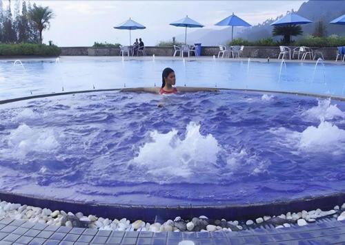 a girl is in a blue pool in a swimming pool at Hotel Niagara Parapat in Parapat