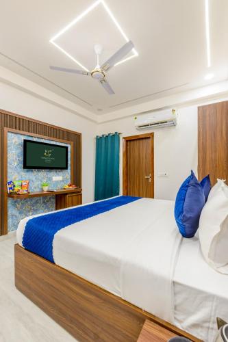 a bedroom with a large bed and a tv at Honeyveils Palace Hotel - Behind Indian Expo Mart in Greater Noida