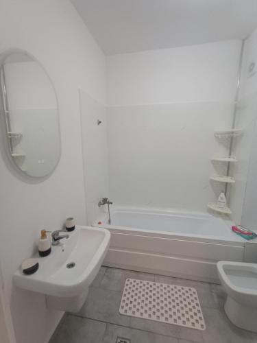 a white bathroom with a sink and a tub at Avangarde House in Chiajna