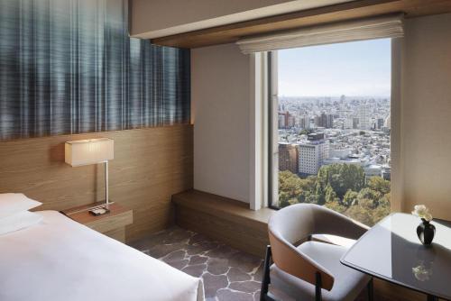 a hotel room with a bed and a desk and a window at Hyatt Regency Tokyo in Tokyo