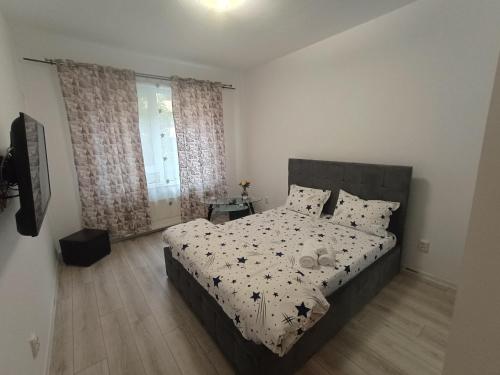 a bedroom with a bed with a black and white comforter at Avangarde House in Chiajna