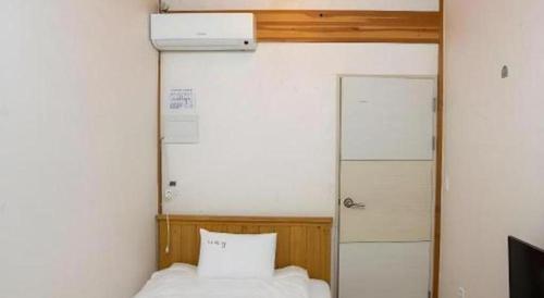 a bedroom with a bed with a pillow and a door at Nabijam Hanok Hotel in Jeonju