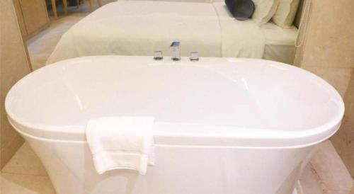 a white toilet in a room with two beds at Shanghai Fuyue Hotel in Shanghai