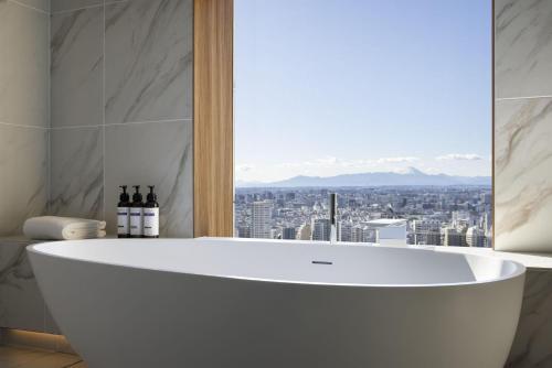 a white bath tub in a bathroom with a window at Hyatt Regency Tokyo in Tokyo