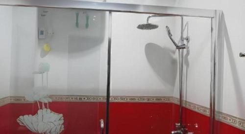 a shower in a bathroom with a red and white wall at Favanhmai Hotel in Muang Phônsavan