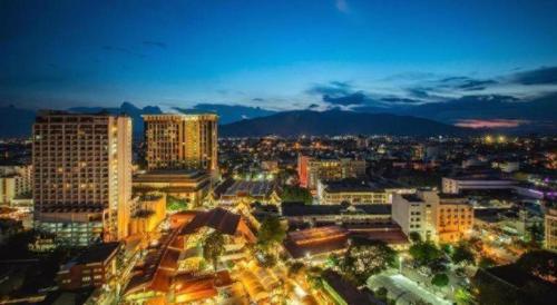 a city lit up at night with buildings at OYO 412 7 Days Hotel in Chiang Mai
