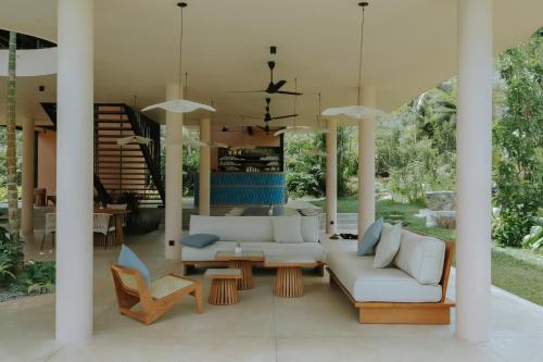 a living room with a white couch and chairs at Sola - Boutique Hotel in Ahangama
