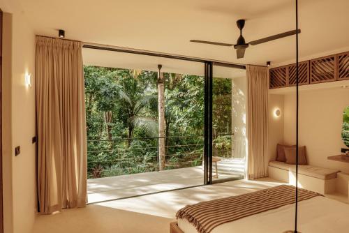 a bedroom with a bed and a large window at Sola - Boutique Hotel in Ahangama