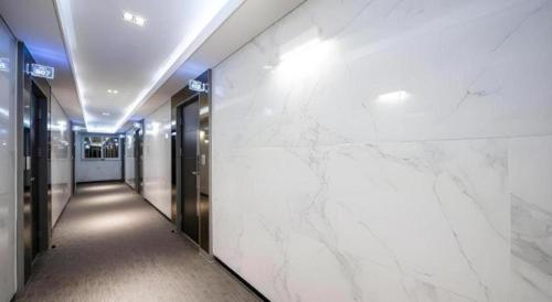 a hallway in a building with white marble walls at Pohang Hotel View in Pohang