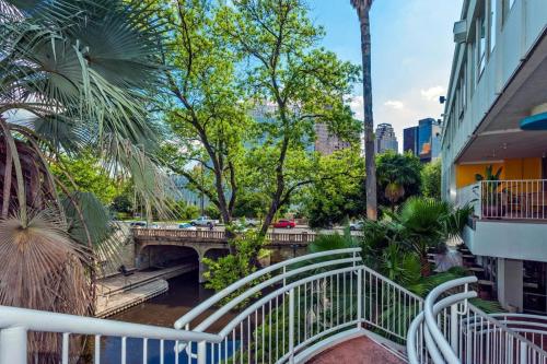 a bridge over a river with a white railing at El Tropicano Riverwalk in San Antonio