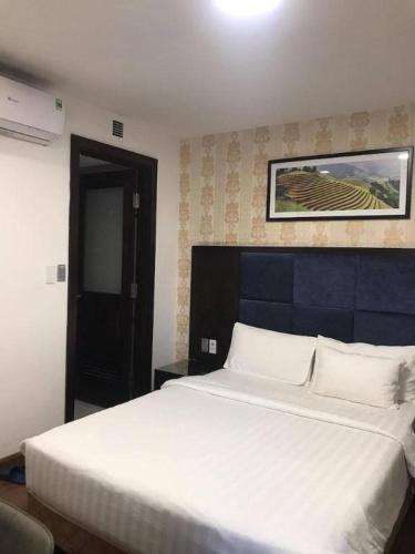 a bedroom with a large white bed in a room at New Moon Hotel in Hanoi