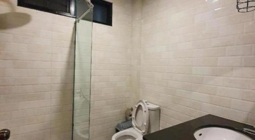 a bathroom with a toilet and a glass shower at THE S VILLAS HOTEL in Nakhon Phanom