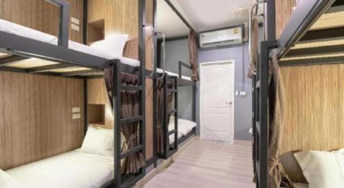 a room with three bunk beds and a hallway at OYO 726 Sookjai Cafe and Hostel in Chiang Mai