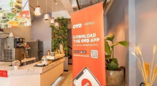 an orange sign in a room with plants at OYO 726 Sookjai Cafe and Hostel in Chiang Mai